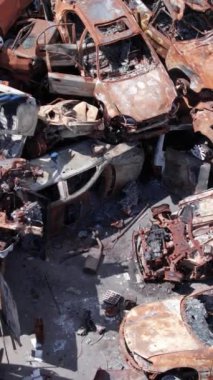 Bu stok dikey video Irpin, Bucha bölgesinde bir kurşun ve yanmış araba dökümü gösteriyor.