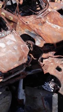 Bu stok dikey video Irpin, Bucha bölgesinde bir kurşun ve yanmış araba dökümü gösteriyor.