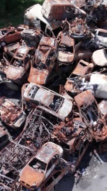 Bu stok dikey video Irpin, Bucha bölgesinde bir kurşun ve yanmış araba dökümü gösteriyor.