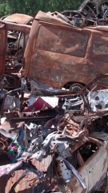 Bu stok dikey video Irpin, Bucha bölgesinde bir kurşun ve yanmış araba dökümü gösteriyor.