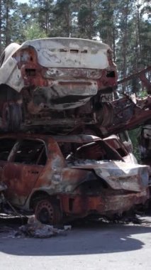 Bu stok dikey video Irpin, Bucha bölgesinde bir kurşun ve yanmış araba dökümü gösteriyor.