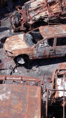 Bu stok dikey video Irpin, Bucha bölgesinde bir kurşun ve yanmış araba dökümü gösteriyor.