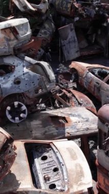 Bu stok dikey video Irpin, Bucha bölgesinde bir kurşun ve yanmış araba dökümü gösteriyor.