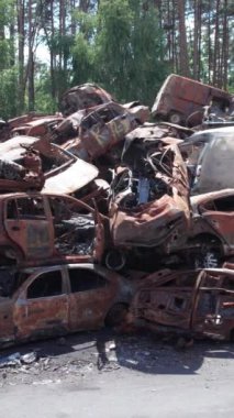 Bu stok dikey video Irpin, Bucha bölgesinde bir kurşun ve yanmış araba dökümü gösteriyor.