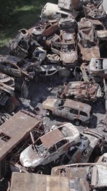 Bu stok dikey video Irpin, Bucha bölgesinde bir kurşun ve yanmış araba dökümü gösteriyor.