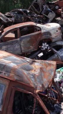 Bu stok dikey video Irpin, Bucha bölgesinde bir kurşun ve yanmış araba dökümü gösteriyor.