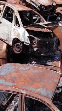 Bu stok dikey video Irpin, Bucha bölgesinde bir kurşun ve yanmış araba dökümü gösteriyor.