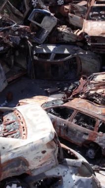 Bu stok dikey video Irpin, Bucha bölgesinde bir kurşun ve yanmış araba dökümü gösteriyor.