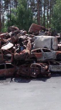 Bu stok dikey video Irpin, Bucha bölgesinde bir kurşun ve yanmış araba dökümü gösteriyor.