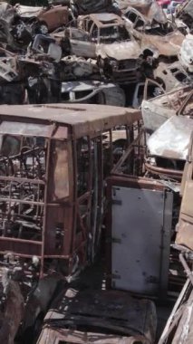 Bu stok dikey video Irpin, Bucha bölgesinde gri, düz, renksiz, yanmış arabaları gösteriyor.