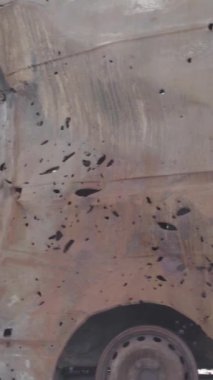 Bu stok dikey video Irpin, Bucha bölgesinde gri, düz, renksiz, yanmış arabaları gösteriyor.