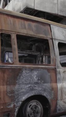 Bu stok dikey video, Bucha 'daki bir alışveriş merkezinin yıkık dökük bir binasını gösteriyor. Ağır çekim, gri, renksiz, düz.