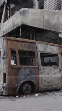 Bu stok dikey video, Bucha 'daki bir alışveriş merkezinin yıkık dökük bir binasını gösteriyor. Ağır çekim, gri, renksiz, düz.