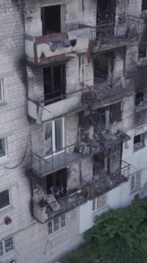 This stock vertical video shows a destroyed building in the city of Makariv during the war in Ukraine, grey, no color, flat
