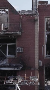This stock vertical video shows a destroyed building in the city of Makariv during the war in Ukraine, grey, no color, flat