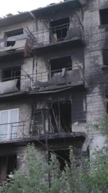 This stock vertical video shows a destroyed building in the city of Makariv during the war in Ukraine, grey, no color, flat