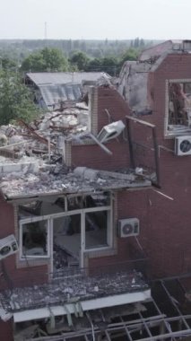 This stock vertical video shows a destroyed building in the city of Makariv during the war in Ukraine, grey, no color, flat