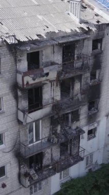 This stock vertical video shows a destroyed building in the city of Makariv during the war in Ukraine, grey, no color, flat
