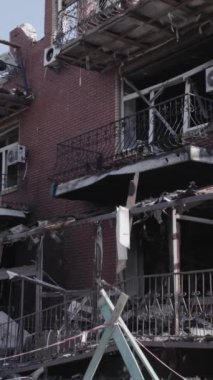 This stock vertical video shows a destroyed building in the city of Makariv during the war in Ukraine, grey, no color, flat