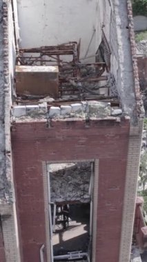 This stock vertical video shows a destroyed building in the city of Makariv during the war in Ukraine, grey, no color, flat