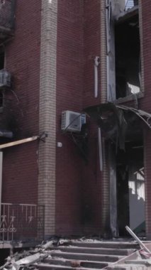 This stock vertical video shows a destroyed building in the city of Makariv during the war in Ukraine, grey, no color, flat