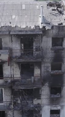 This stock vertical video shows a destroyed building in the city of Makariv during the war in Ukraine, grey, no color, flat