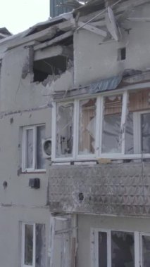 This stock vertical video shows a destroyed building in the city of Makariv during the war in Ukraine, grey, no color, flat