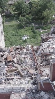 Bu dikey video Ukrayna 'daki savaş sırasında Makariv şehrinde yıkılmış bir binayı gösteriyor. Gri, renksiz, düz.