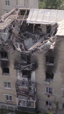 This stock vertical video shows a destroyed building in the city of Makariv during the war in Ukraine, grey, no color, flat