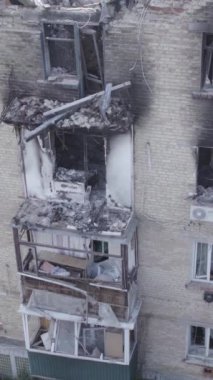 This stock vertical video shows a destroyed building in the city of Makariv during the war in Ukraine, grey, no color, flat