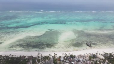 This stock video shows an aerial view of the ocean near the coast of Zanzibar, Tanzania, slow motionin in 8K resolution