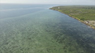 This stock video shows an aerial view of the ocean near the coast of Zanzibar, Tanzania, slow motionin in 8K resolution