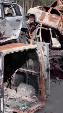 Bu stok dikey video Irpin, Bucha bölgesinde bir kurşun ve yanmış araba dökümü gösteriyor.