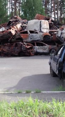 Bu stok dikey video Irpin, Bucha bölgesinde bir kurşun ve yanmış araba dökümü gösteriyor.