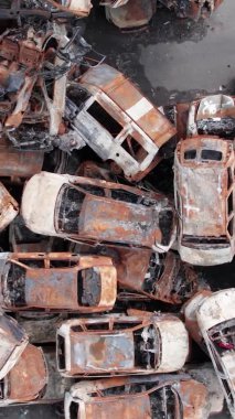 Bu stok dikey video Irpin, Bucha bölgesinde bir kurşun ve yanmış araba dökümü gösteriyor.