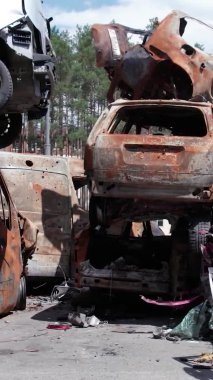 Bu stok dikey video Irpin, Bucha bölgesinde bir kurşun ve yanmış araba dökümü gösteriyor.