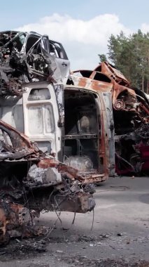 Bu stok dikey video Irpin, Bucha bölgesinde bir kurşun ve yanmış araba dökümü gösteriyor.