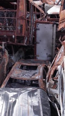 Bu stok dikey video Irpin, Bucha bölgesinde bir kurşun ve yanmış araba dökümü gösteriyor.