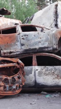 Bu stok dikey video Irpin, Bucha bölgesinde bir kurşun ve yanmış araba dökümü gösteriyor.