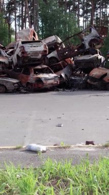 Bu stok dikey video Irpin, Bucha bölgesinde bir kurşun ve yanmış araba dökümü gösteriyor.