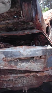 Bu stok dikey video Irpin, Bucha bölgesinde bir kurşun ve yanmış araba dökümü gösteriyor.