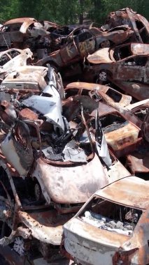 Bu stok dikey video Irpin, Bucha bölgesinde bir kurşun ve yanmış araba dökümü gösteriyor.