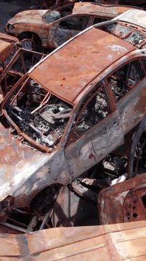 Bu stok dikey video Irpin, Bucha bölgesinde bir kurşun ve yanmış araba dökümü gösteriyor.