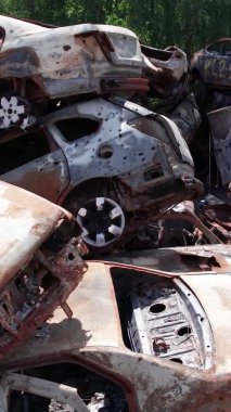 Bu stok dikey video Irpin, Bucha bölgesinde bir kurşun ve yanmış araba dökümü gösteriyor.