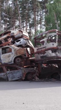 Bu stok dikey video Irpin, Bucha bölgesinde bir kurşun ve yanmış araba dökümü gösteriyor.