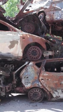 Bu stok dikey video Irpin, Bucha bölgesinde bir kurşun ve yanmış araba dökümü gösteriyor.