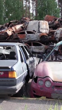 Bu stok dikey video Irpin, Bucha bölgesinde bir kurşun ve yanmış araba dökümü gösteriyor.