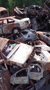 Bu stok dikey video Irpin, Bucha bölgesinde bir kurşun ve yanmış araba dökümü gösteriyor.