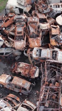 Bu stok dikey video Irpin, Bucha bölgesinde bir kurşun ve yanmış araba dökümü gösteriyor.