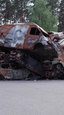 Bu stok dikey video Irpin, Bucha bölgesinde bir kurşun ve yanmış araba dökümü gösteriyor.